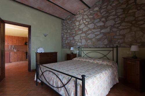 a bedroom with a bed and a stone wall at Tenuta Agricola dell'Uccellina in Talamone