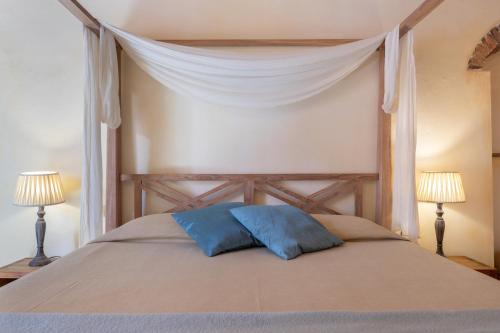 a bed with two blue pillows on top of it at Hotel Al Convento in Vezzano Ligure