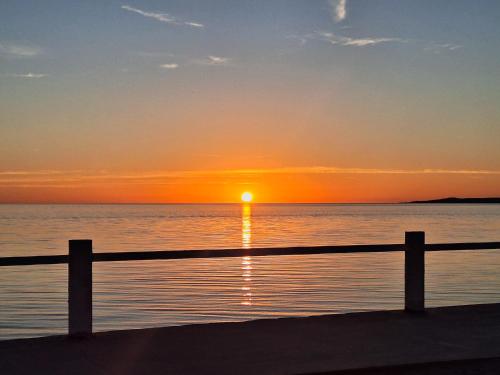 a sunset over the water with a wooden fence at #39 Bungalow Seaside Hotel & Victors RV Park in San Felipe