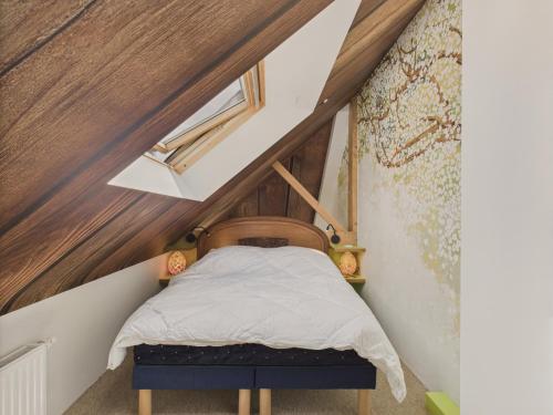 a small bedroom with a bed in the attic at 300m plage - duplex avec jardin pour 4 in Sarzeau