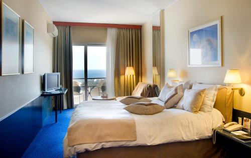 a hotel room with a large bed and a television at Egnatia City Hotel & Spa in Kavala