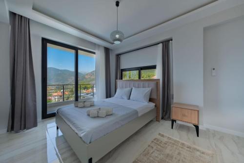 a bedroom with a large bed and large windows at Villa DeFnE Fethiye in Fethiye