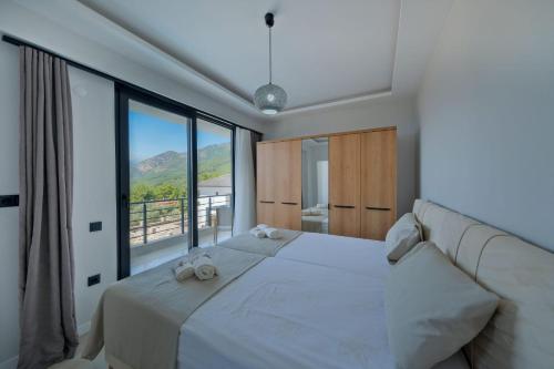 a bedroom with a large bed with a large window at Villa DeFnE Fethiye in Fethiye