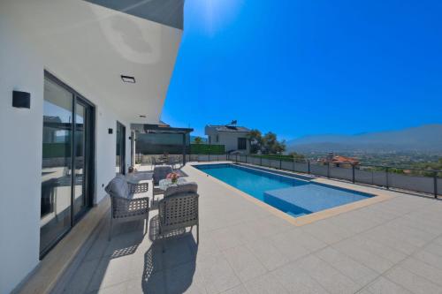 a house with a swimming pool on a balcony at Villa DeFnE Fethiye in Fethiye