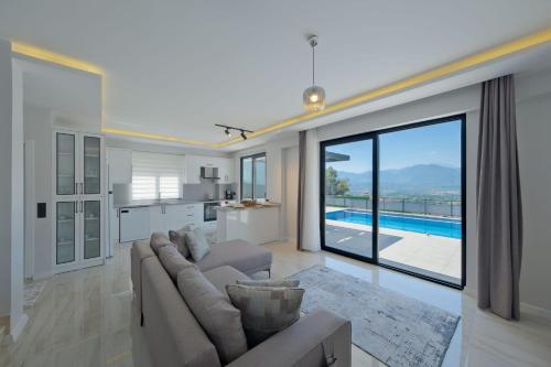 a living room with a couch and a large window at Villa DeFnE Fethiye in Fethiye
