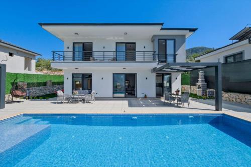 a villa with a swimming pool in front of a house at Villa DeFnE Fethiye in Fethiye