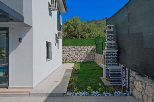 a building with a staircase next to a wall at Villa DeFnE Fethiye in Fethiye