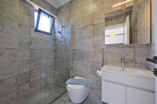 a bathroom with a toilet and a sink at Villa DeFnE Fethiye in Fethiye
