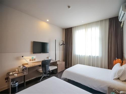 Habitación de hotel con 2 camas y escritorio en Jinjiang Inn Xiamen Jimei University Guomao en Xiamen