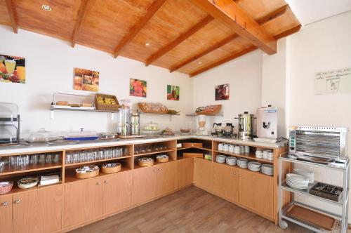 cocina con armarios de madera y encimera en Hostal Residencia Europa Punico, en Ibiza