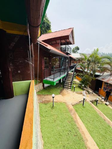 a view of a building with a porch and grass at Ella CityZing Hostel in Ella