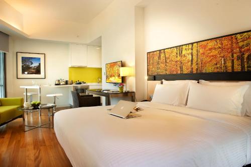 a hotel room with a bed with a laptop on it at The Signature Hotel & Serviced Suites Kuala Lumpur in Kuala Lumpur