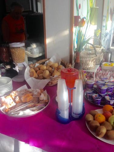a table with plates of food on a pink table at Hotel Flora in Cesenatico