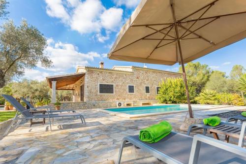 a patio with an umbrella and a swimming pool at Finca Isabel y Guillermo con posibilidad de piscina climatizada in Sineu