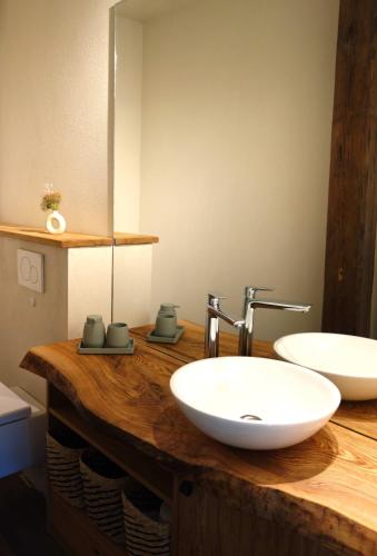 a bathroom with two sinks on a wooden counter at HexenburgbeiDresden 3 Zimmer Architektengaleriewohnung mit eigener Sauna, 2 Kaminen - Nähe Sächsische Schweiz Dresden in Großharthau