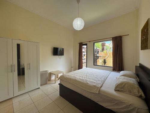 a bedroom with a large bed and a window at The Paradise Bali in Badung