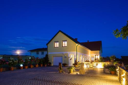 a white house at night with lights on at Appartementhaus Freiler in Mörbisch am See