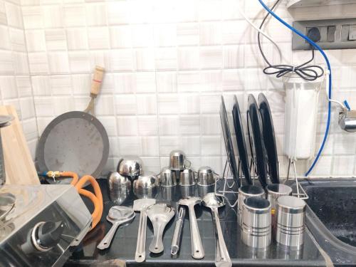 a kitchen counter top with utensils and utensils at 2BHk Homestay Opp Mysore Zoo, Kamadhenu Homestay B in Mysore