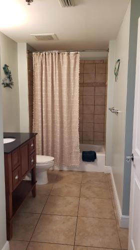 a bathroom with a toilet and a sink and a shower at Romantic Beachfront Sunsets in Panama City Beach