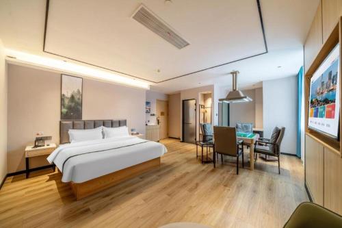 ein Hotelzimmer mit einem Bett und einem Esszimmer in der Unterkunft GreenTree Inn Suzhou North Zhongshan Road Weiye Yingchun Plaza Business Hotel in Suzhou