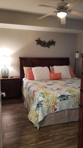 a bedroom with a bed and a ceiling fan at Romantic Beachfront Sunsets in Panama City Beach
