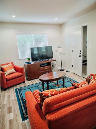 a living room with a couch and a table and a tv at Hollywood Boutique Residences with Free Parking in Los Angeles
