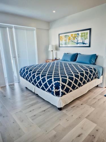 a bedroom with a bed with a blue comforter at Hollywood Boutique Residences with Free Parking in Los Angeles