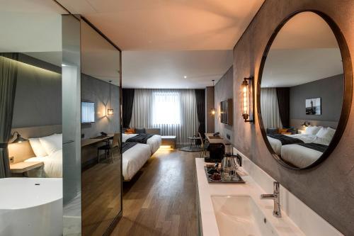 a bathroom with two beds and a mirror and a tub at Hotel28 Myeongdong in Seoul