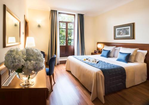 a hotel room with a bed and a vase of flowers at Hotel Ponte Sisto in Rome