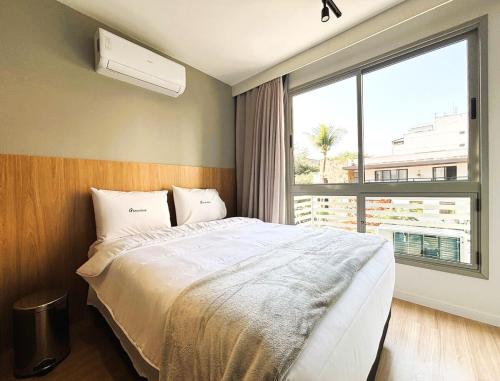 um quarto com uma cama e uma janela grande em Unihome Studio em Niterói
