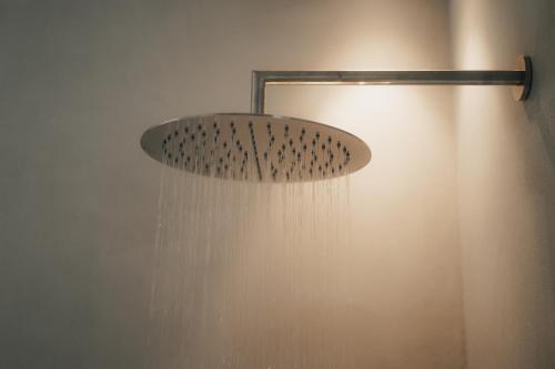 a shower with a shower head with water coming out at Chalet Herol in Luson