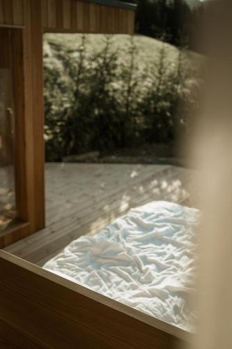 a bed sitting inside of a glass window at Chalet Herol in Luson