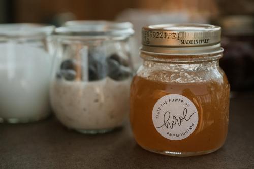 a jar of honey next to other jars of food at Chalet Herol in Luson
