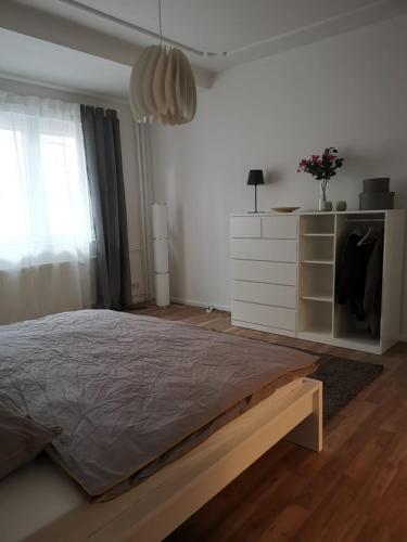 a white bedroom with a bed and a dresser at Wunderschönes Single Apartment in Berlin