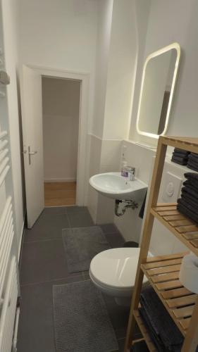 a bathroom with a white toilet and a sink at Wunderschönes Single Apartment in Berlin