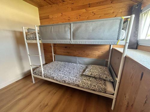 Dos literas en una habitación con suelo de madera. en 767 - Maison dans un lieu calme à 850m de la plage, en Erquy