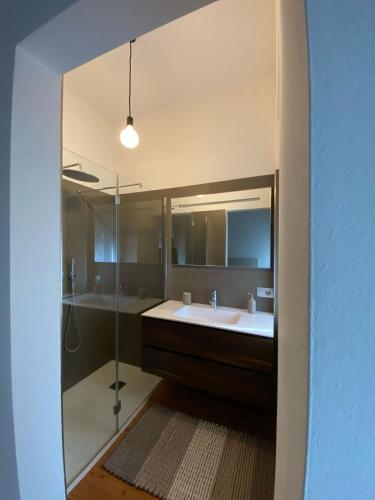 a bathroom with a sink and a shower and a mirror at Balina apartment in Tenno
