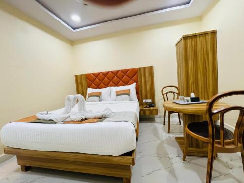 a bedroom with a bed and a table and a desk at Riverside Retreat Dombivli in Dombivli