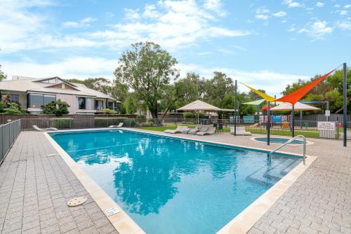 a swimming pool in a yard with a house at Cape View 26 Your Perfect Coastal Retreat in Broadwater