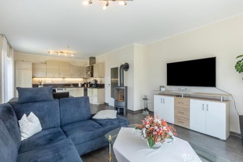 a living room with a blue couch and a tv at Ferienwohnung Lahnurlaub in Huttenberg