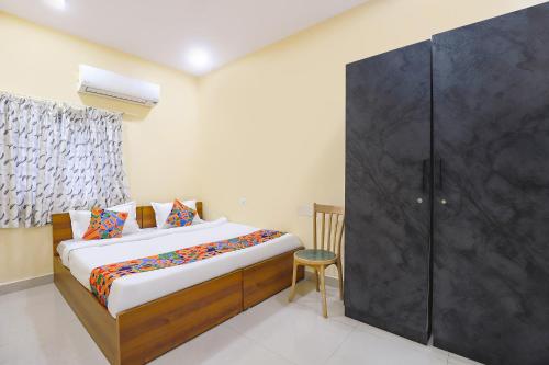 a bedroom with a bed and a large glass closet at FabHotel GT Empire in Chennai