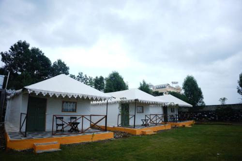 a couple of white tents in a yard at Gaj Niwas Resort and Restaurant in Dakan Kotra