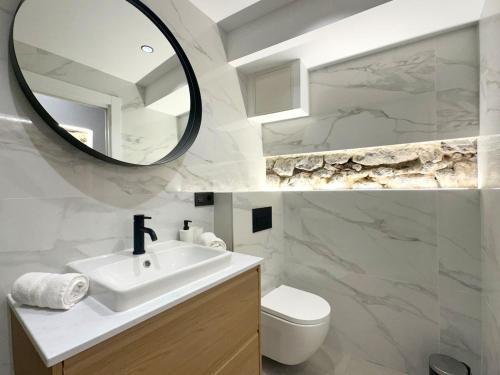 a white bathroom with a sink and a mirror at House with a patio in the center in Laredo