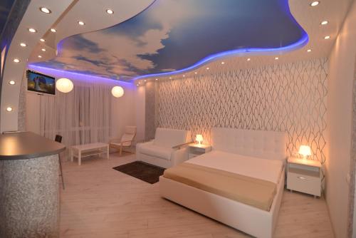 a bedroom with a white bed and a blue ceiling at MEGAPOLIS проспект Революции 9-А-239 in Voronezh