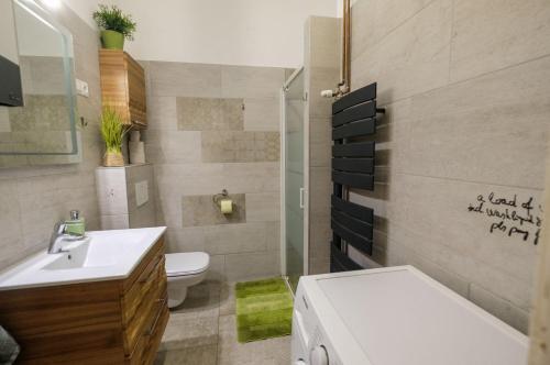 a bathroom with a white sink and a toilet at Pesto private rooms in Budapest