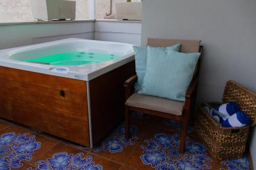 a bath tub with a chair and a pillow next to it at Manna Blue Sky - Exclusive Rooms in Barletta