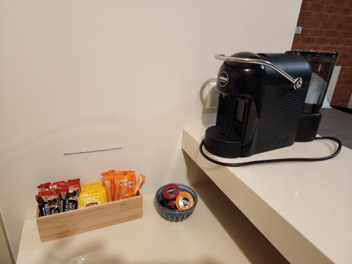 a coffee maker on a counter next to a box of snacks at Sun River Resort in Mildura