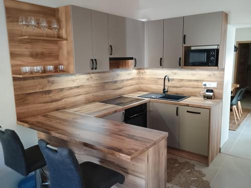a kitchen with a wooden counter top and a sink at Chalúpka pod Hradom Lednica 