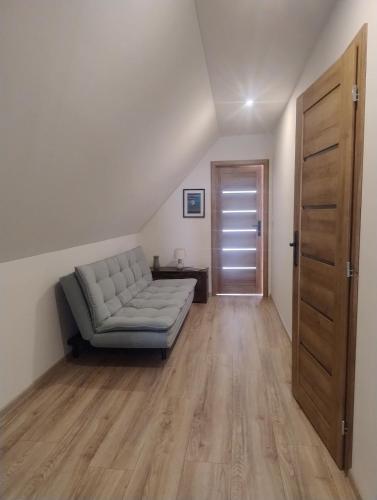 a living room with a couch and a wooden floor at Chalúpka pod Hradom Lednica 