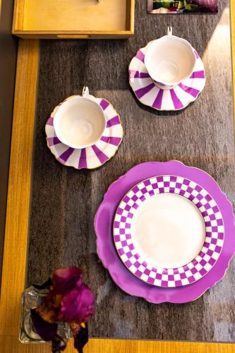 two plates on a table with purple and white at Hotel Corona in Spiazzi Di Caprino